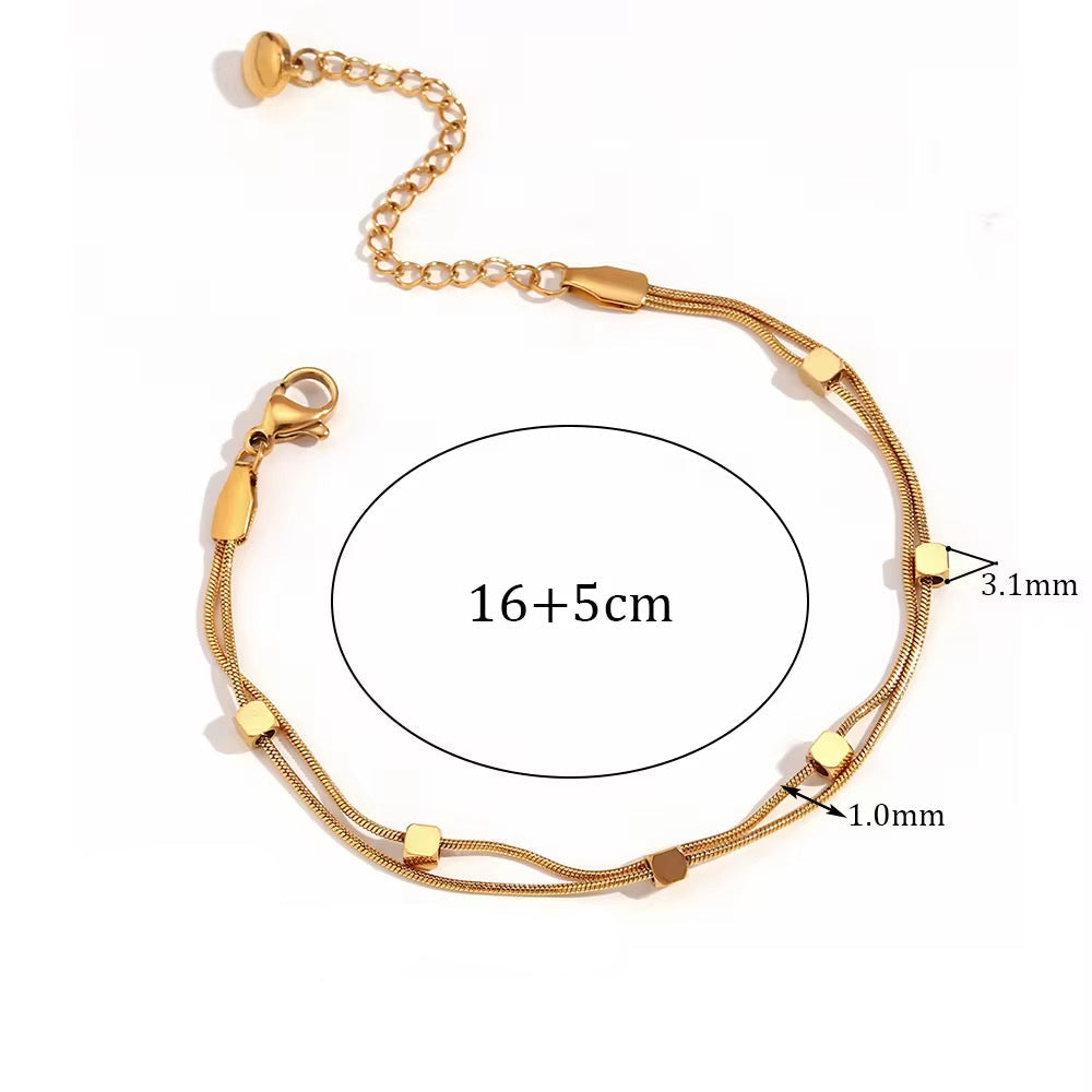 Gold bracelet with measurements and material details on a white background