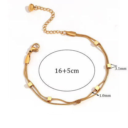 Gold bracelet with measurements and material details on a white background