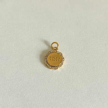 Gold 11:11 charm with engraved text on a light gray background