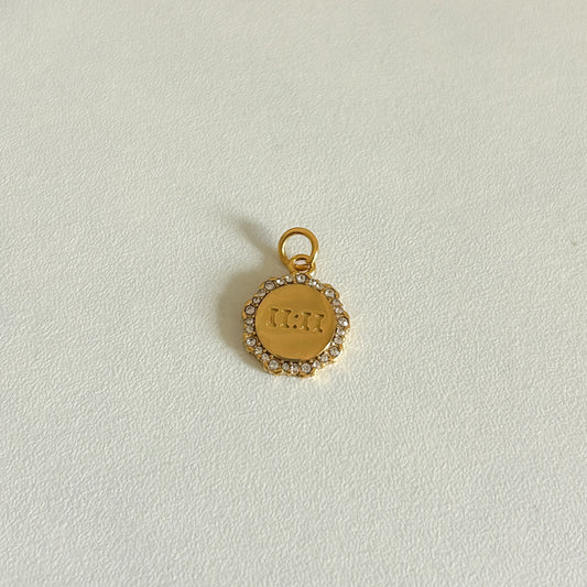 Gold 11:11 charm with engraved text on a light gray background