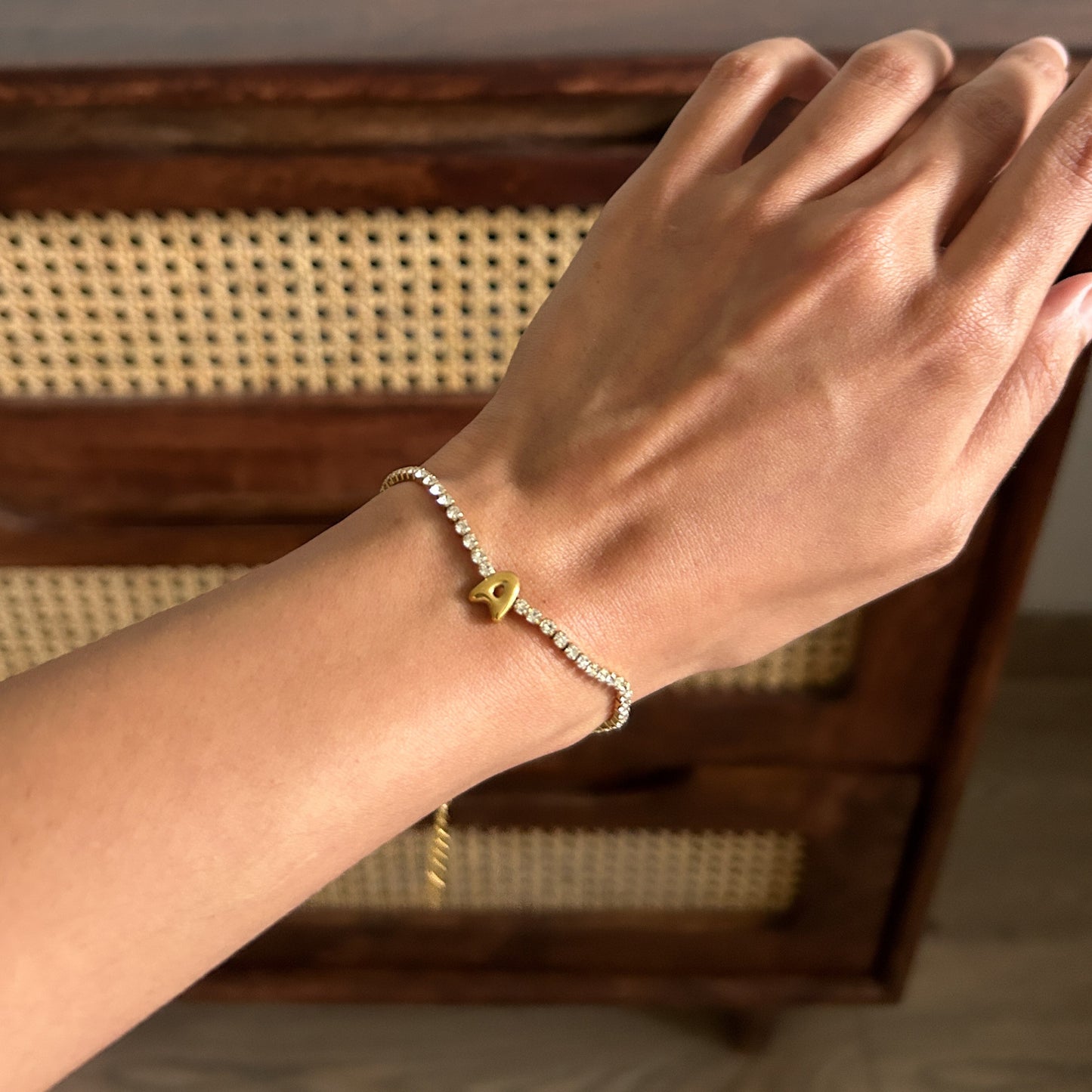 Hand wearing a bracelet on a wooden surface